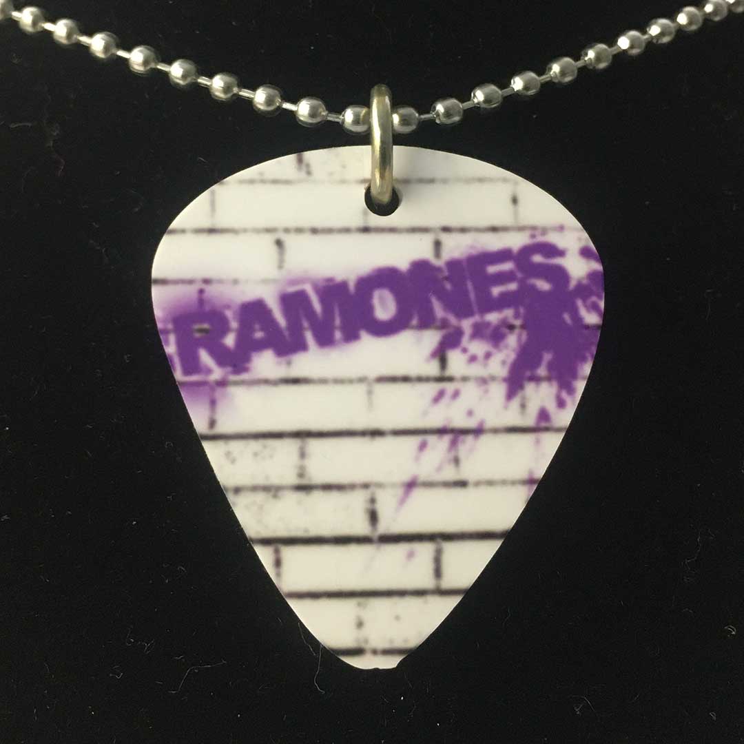 Collana con ciondolo a forma di plettro Ramones scritta sul muro